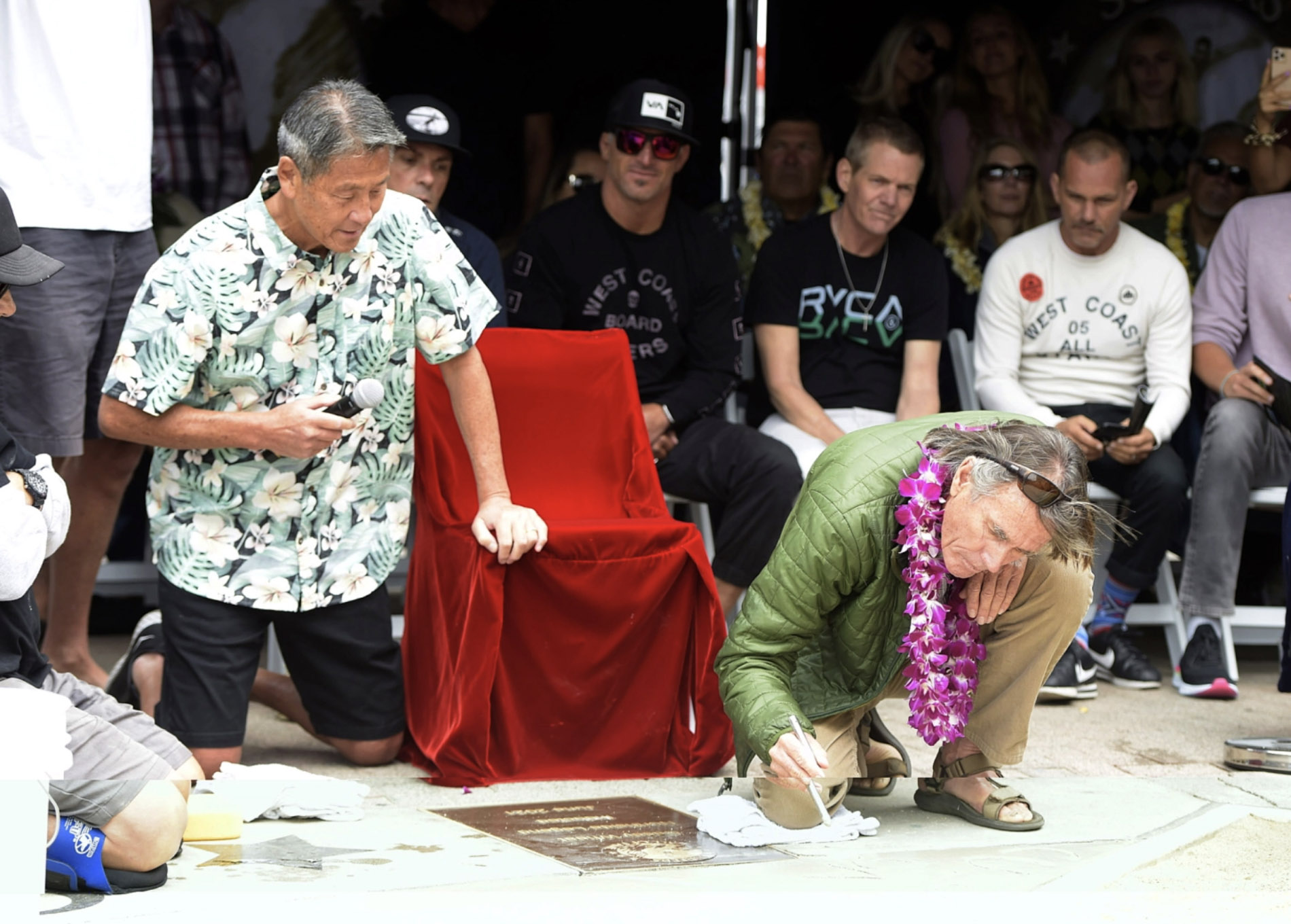 People stand by a large poster of well-known Huntington Beach surfer Casey Wheat, during the Surfers’ Hall of Fame ceremony posthumously inducting Wheat, co-creator of the West Coast Board Riders Club, into the Surfers’ Hall of Fame on Friday morning, June 4, 2021 in Huntington Beach. (Photo by Mark Rightmire, Orange County Register/SCNG)