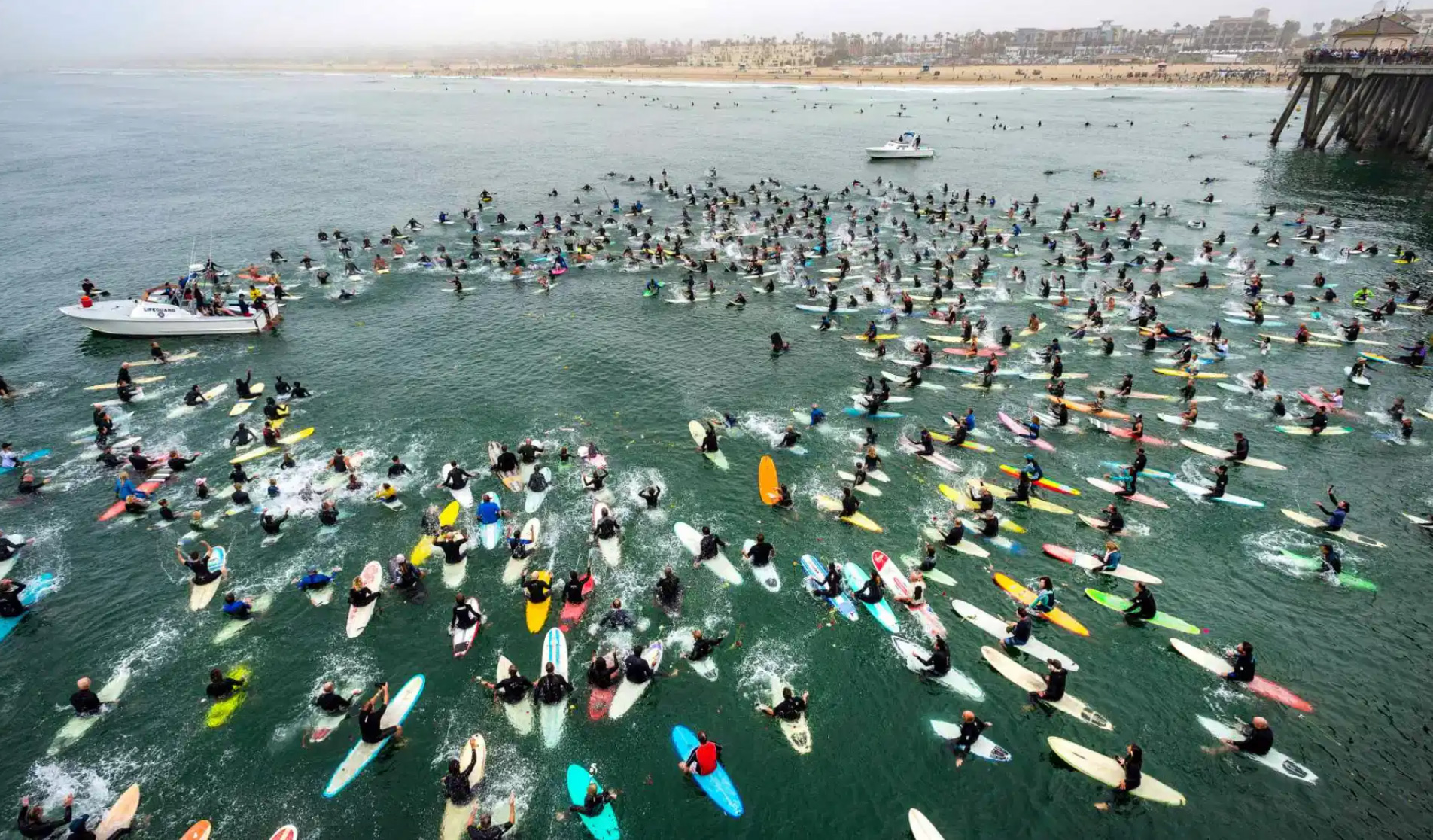 Hundreds of surfers form a circle near the end of the Huntington Beach Pier during a paddle-out for Rick, Rockin’ Fig, Fignetti on Saturday, August 28, 2021 in Huntington Beach. Fignetti of Huntington Beach was a surfer, surf shop owner, and voice of surfing for many years and died on July 16 of a heart attack. (Photo by Mark Rightmire, Orange County Register/SCNG)