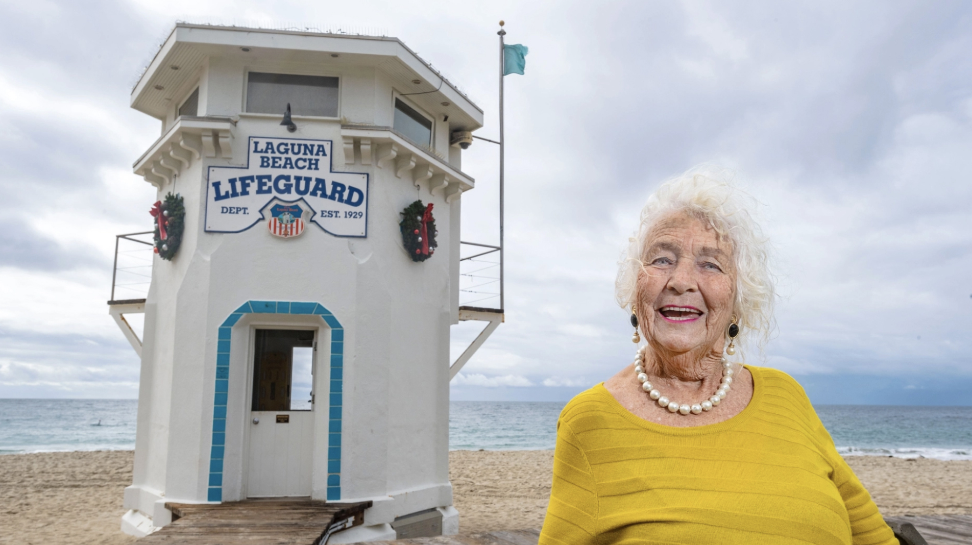 Beth Leeds, of Laguna Beach, a longtime activist and environmentalist, stands next to the lifeguard tower on Main Beach in Laguna Beach on Wednesday, December 29, 2021. Leeds was one of the people that helped save the lifeguard tower from destruction 50 years ago when the city removed the structures there to create the present day boardwalk. (Photo by Mark Rightmire, Orange County Register/SCNG)