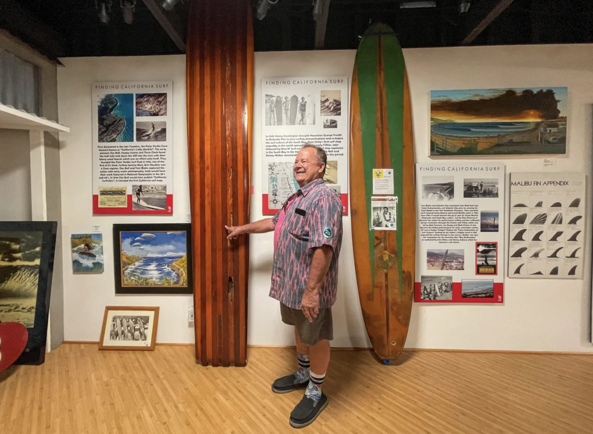 PT Townend shows off some historic wooden surfboards that are part of a new exhibit exploring California surf breaks and the history of how they were discovered at the Huntington Beach International Surfing Museum in Huntington Beach, CA, on Tuesday, November 30, 2021. (Photo by Jeff Gritchen, Orange County Register/SCNG)